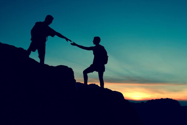 motivasyon-1 iç motivasyonun faydaları nelerdir? dağda yürüyüş yapan 2 insan birbirlerine destek oluyorlar